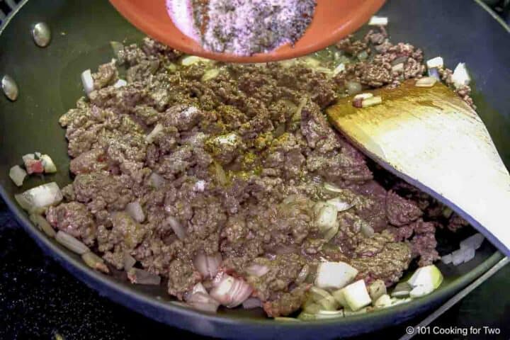 adding spices as ground beef browns.