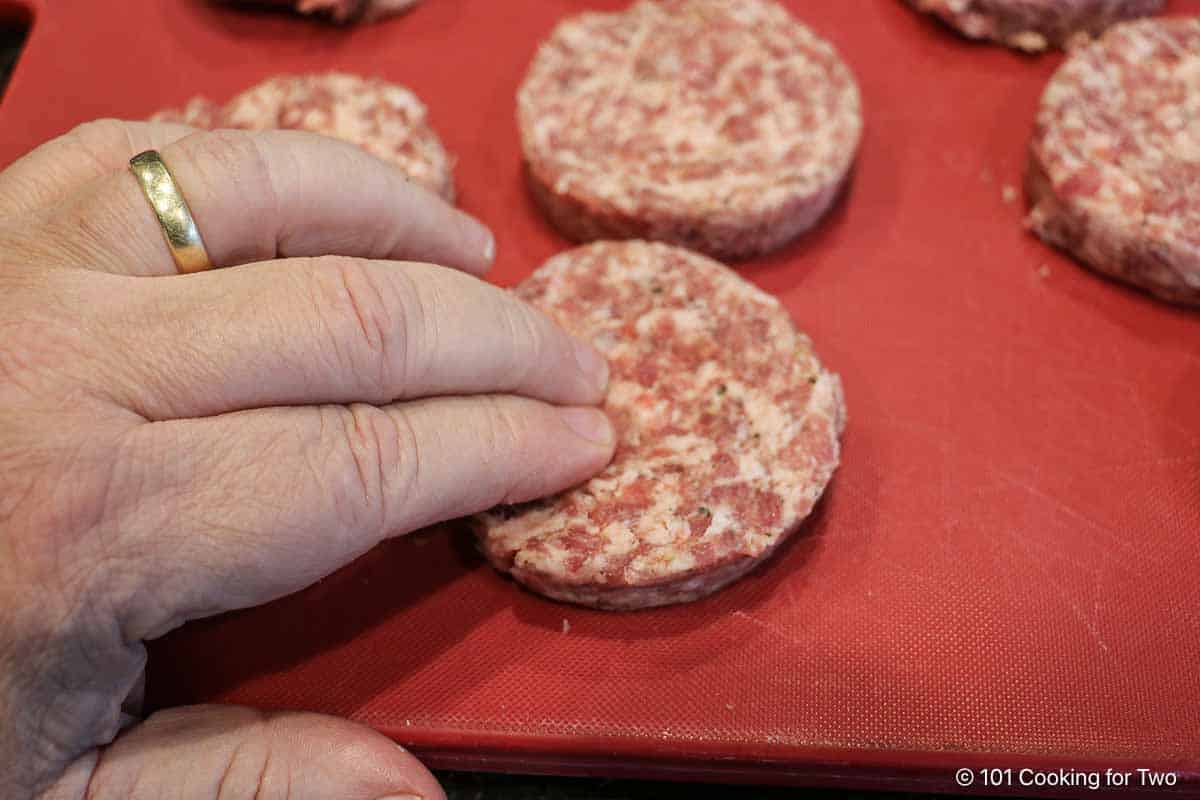 dimpling center of raw sausage pattie.