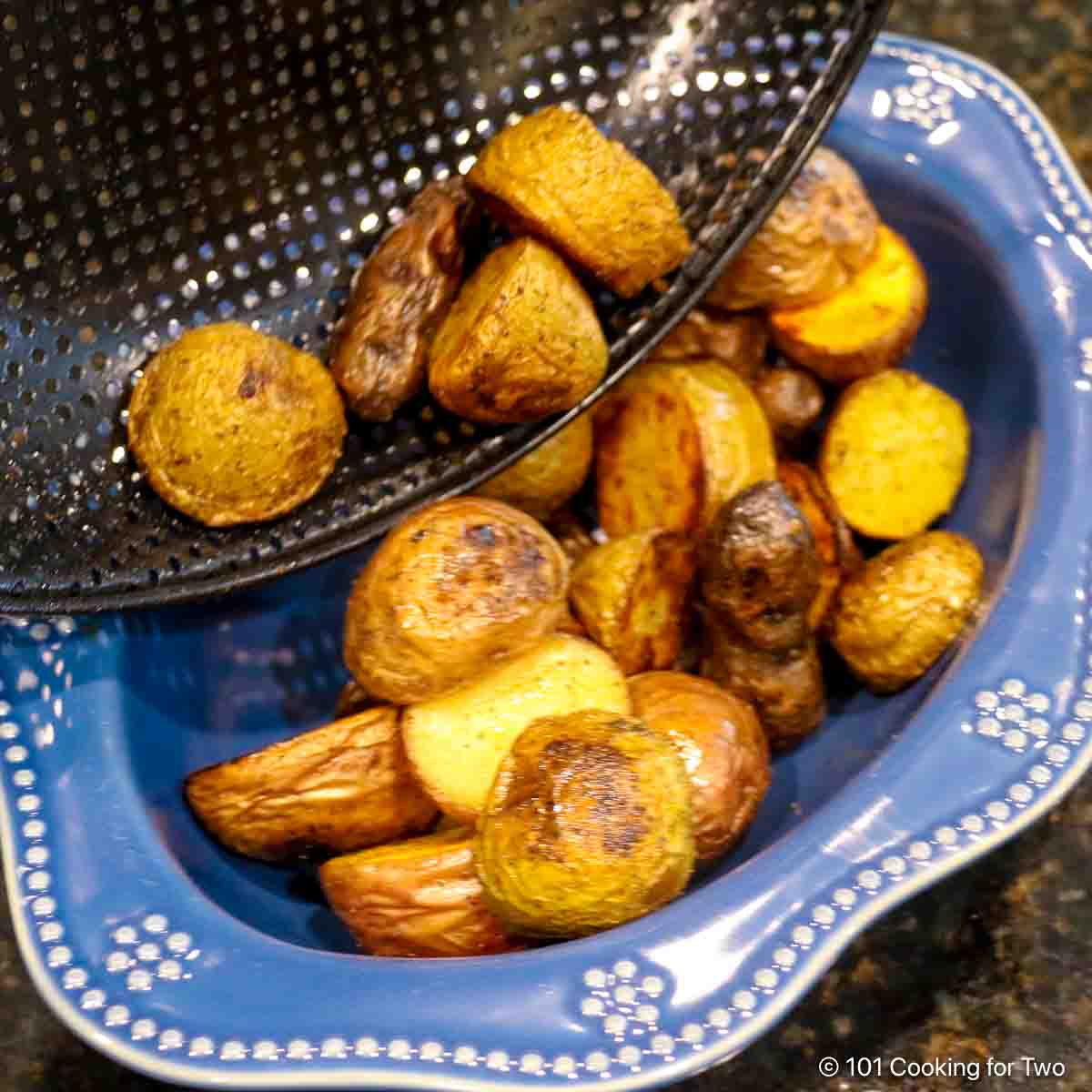pouring small potatoes into blue bowl.