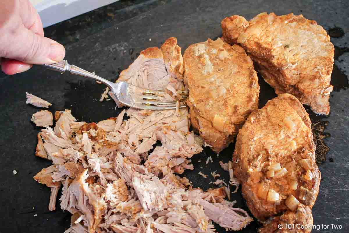 shredding pork loin with a fork.