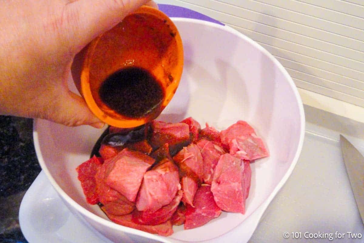 Coating the meat cubes with marinade.