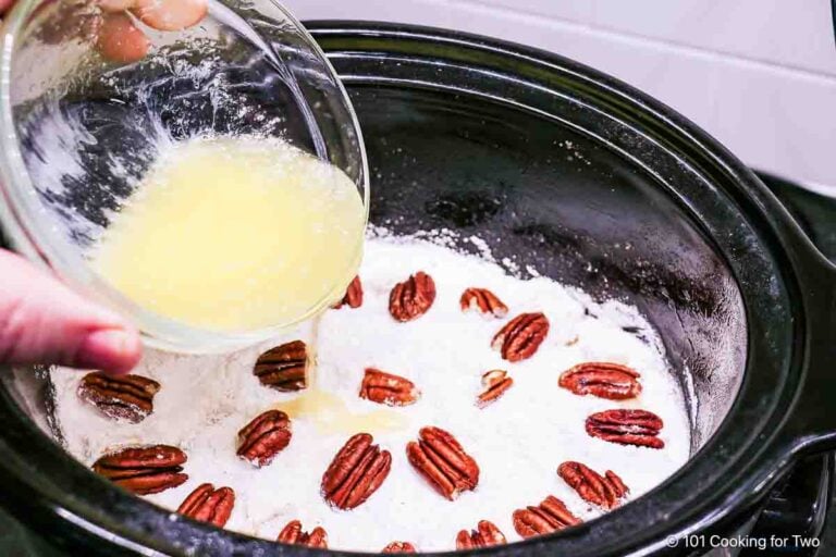 Pouring melted butter over the cobbler.