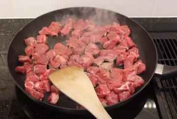 Browning cubes of chuck roast in a skilletBrowning cubes of chuck roast in a skillet