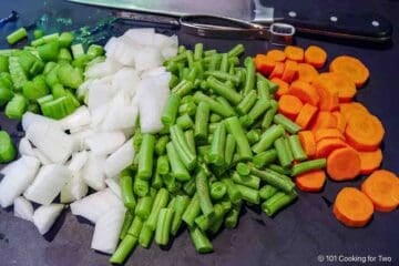 Chopped vegetables on a black board.