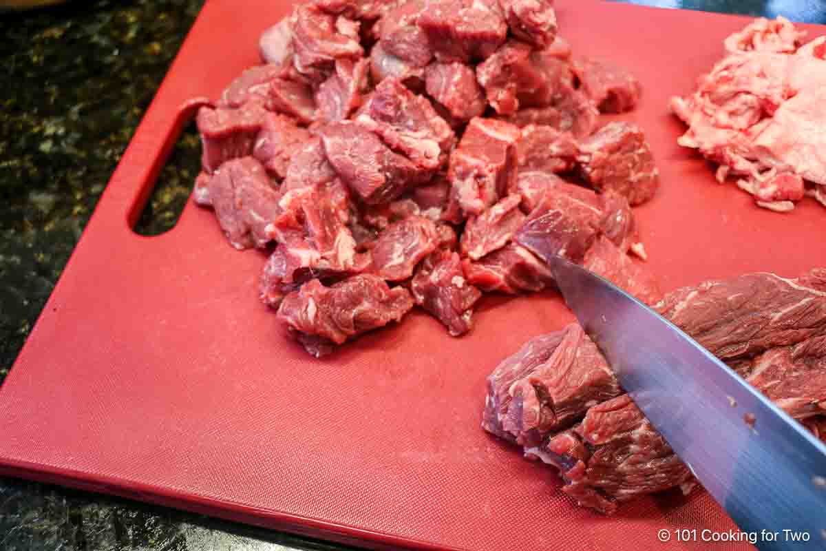 Trimming a chuck roast into cubes.