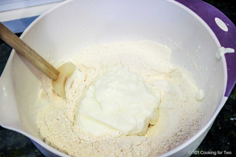 Mixing yogurt into flour mixture with spatula.