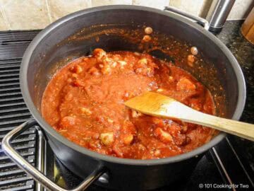 Mixing sauce ingredients with the cooked chicken.