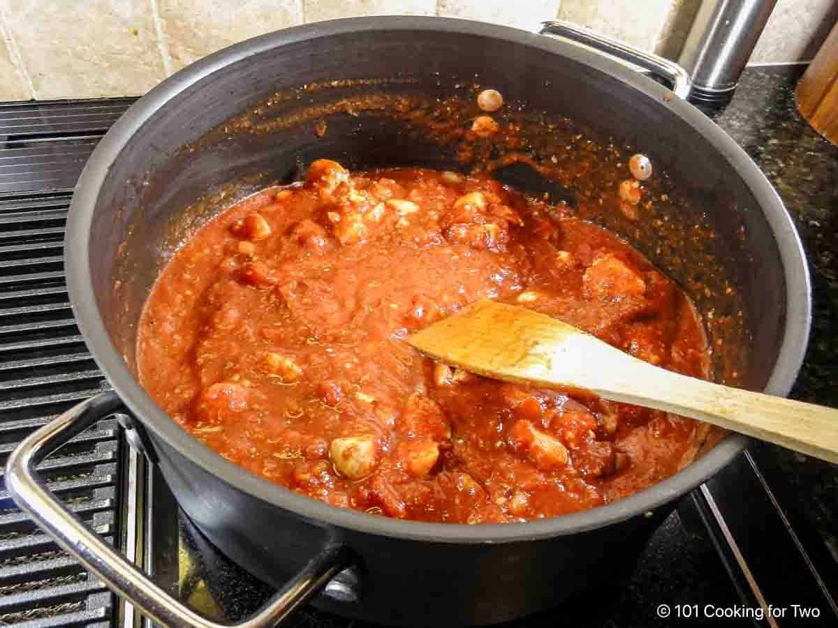 Mixing sauce ingredients with the cooked chicken.