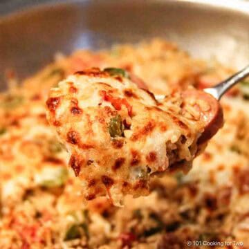 Cheesy chicken and sausage jambalaya on a fork-labeled.