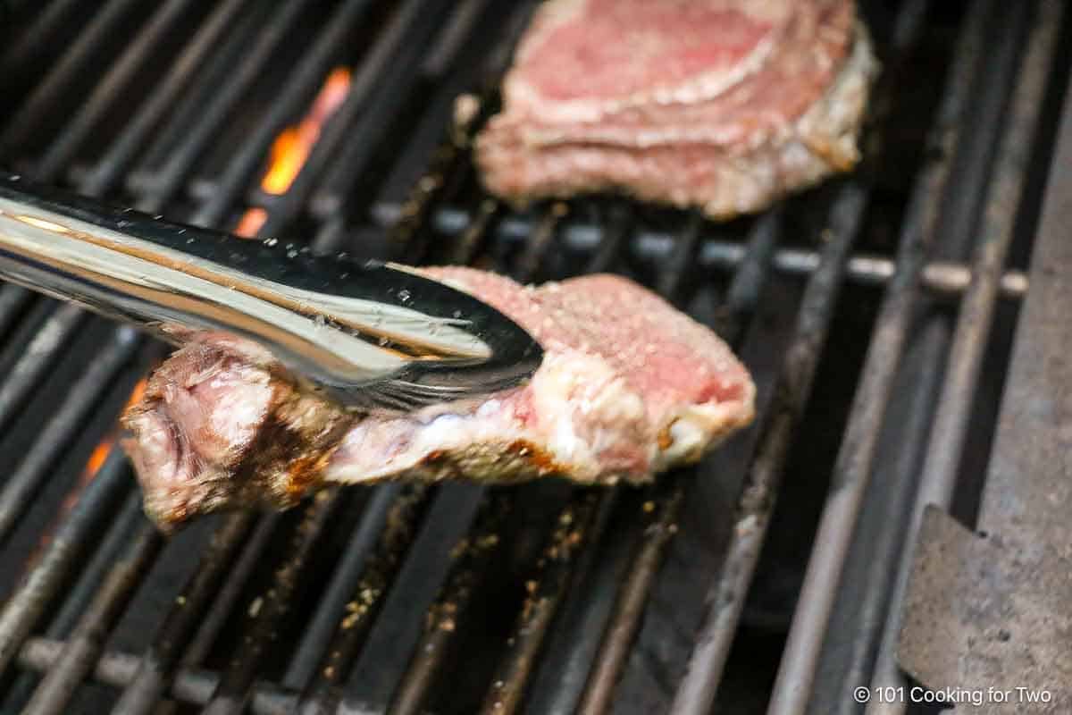 Flipping ribeyes on the grill.