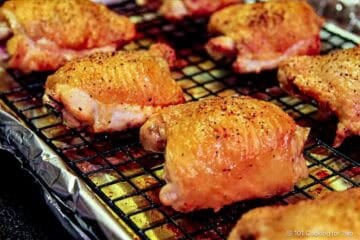 Golden brown cooked thighs on a tray.
