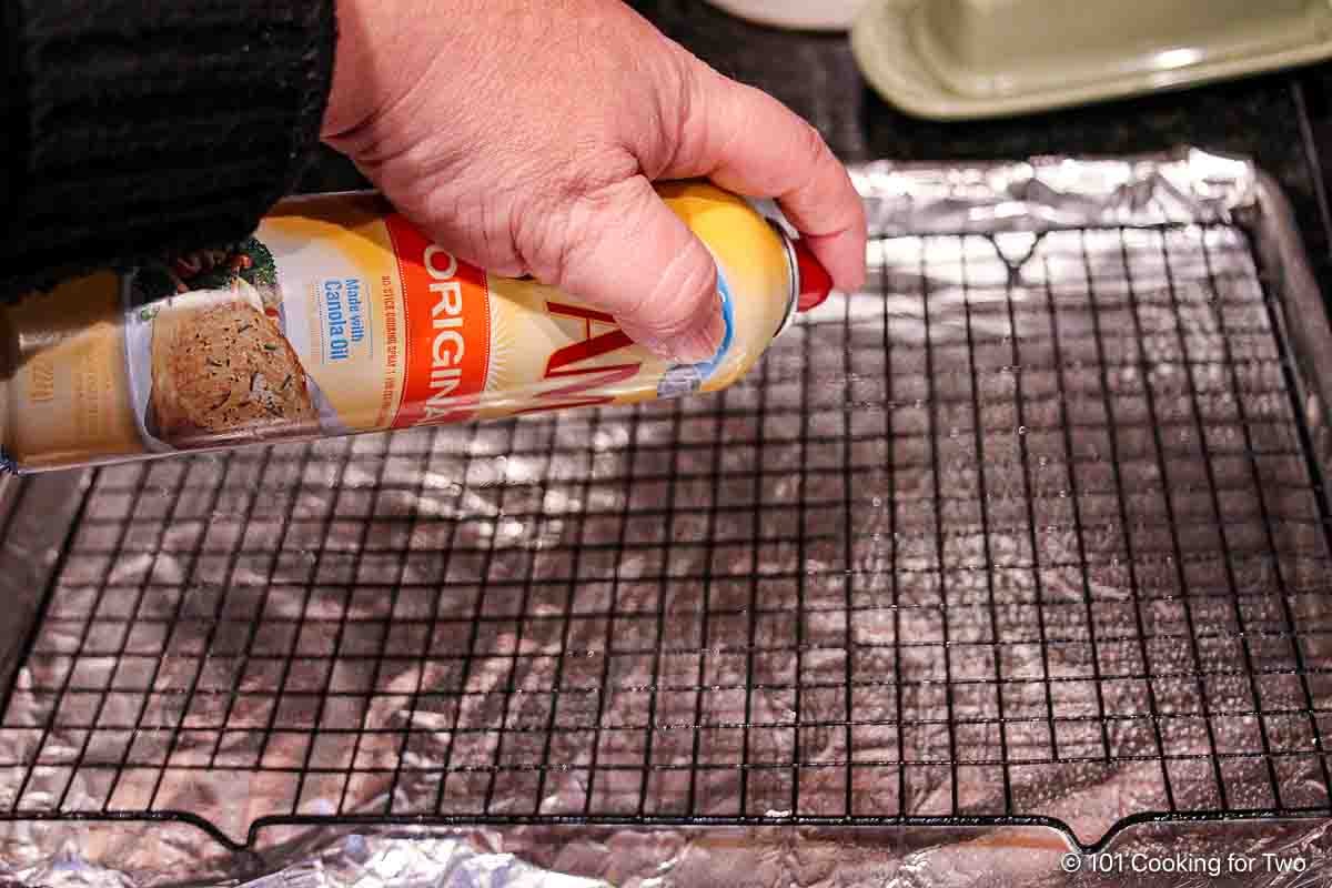 Prepare a tray with a rack, foil, and cooking spray.