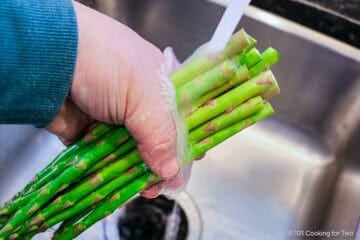 Rinsing trimmed asparagus.