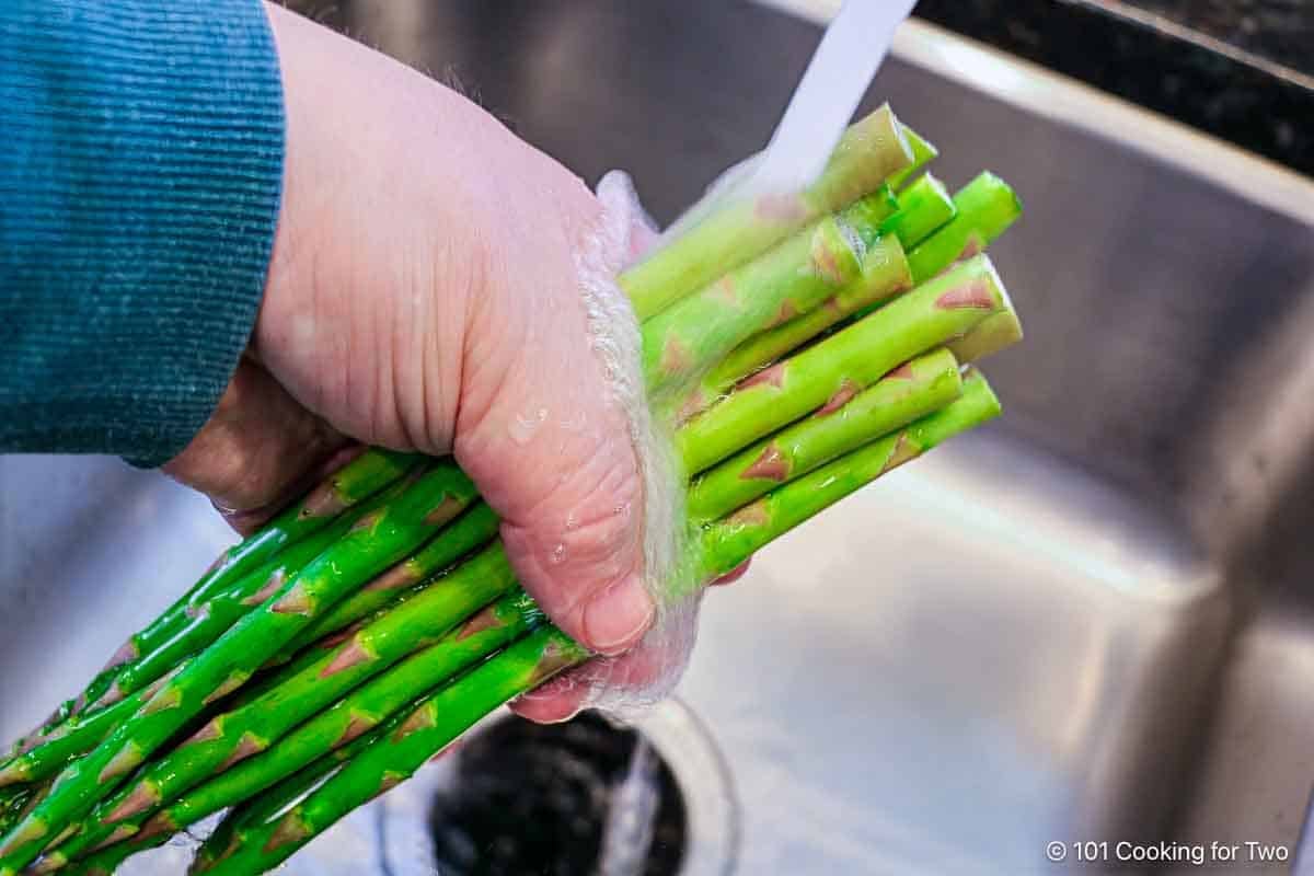 Rinsing trimmed asparagus.