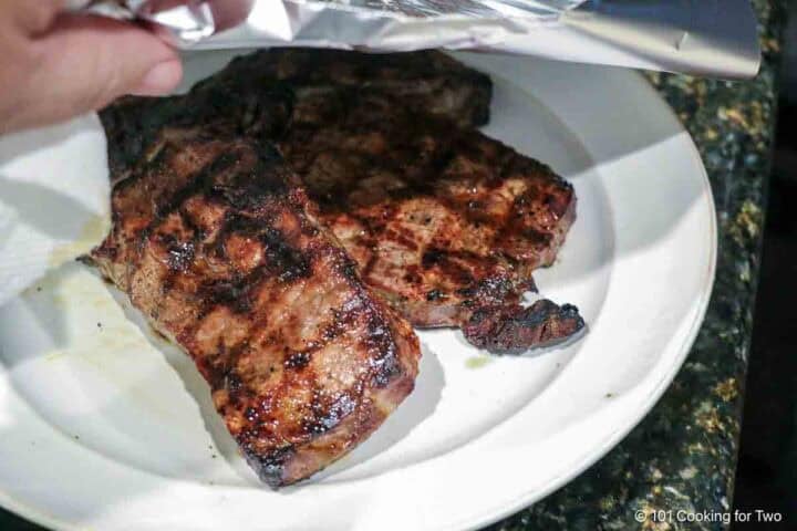 Tenting steaks with foil.