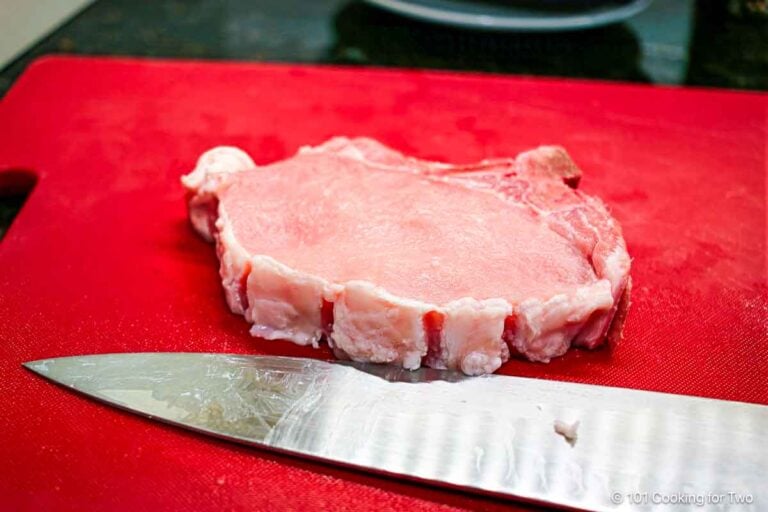 Trimmed pork chop with the knife.