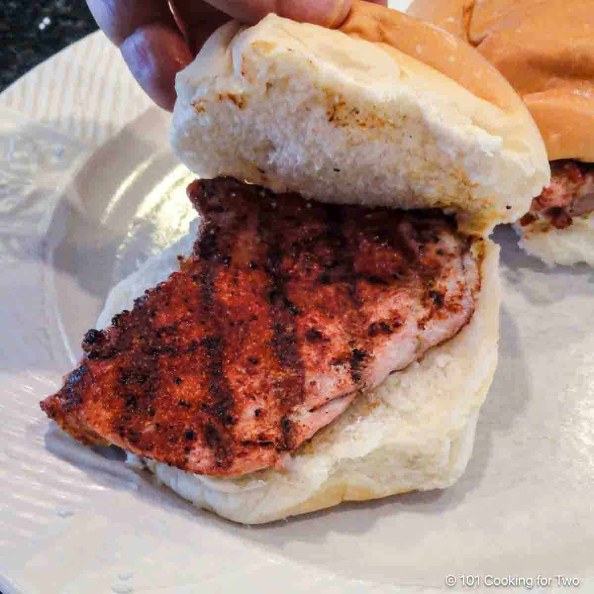 Grilled pork tenderloin sandwich on a plate.