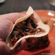 Shredded carnitas in a tortilla.