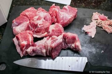 Trimming a pork butt into two-inch cubes.