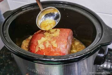 Basting the ham with pineapple fluid.