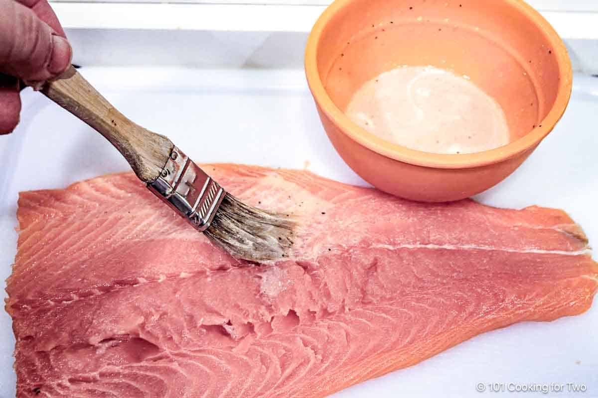 Brushing the salmon with lemon butter.