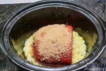 Coated ham on crushed pineapple in the crock pot.