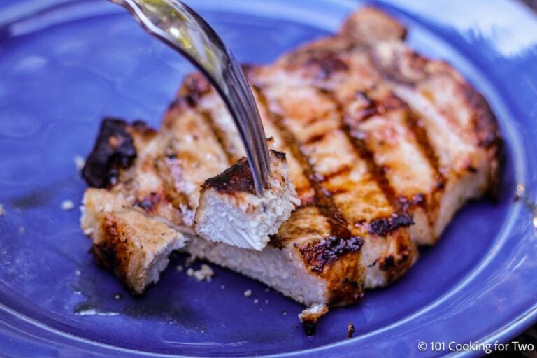Bite of pork chop on a fork.