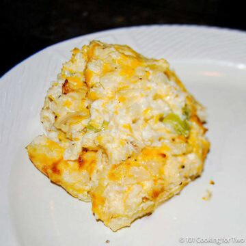 Cheesy cauliflower casserole on a white plate.