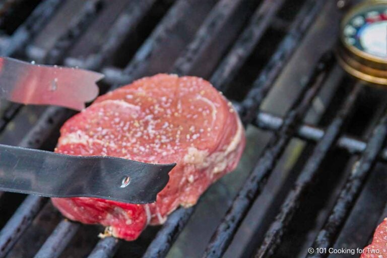 Filet mignon searing on a hot gas grill.