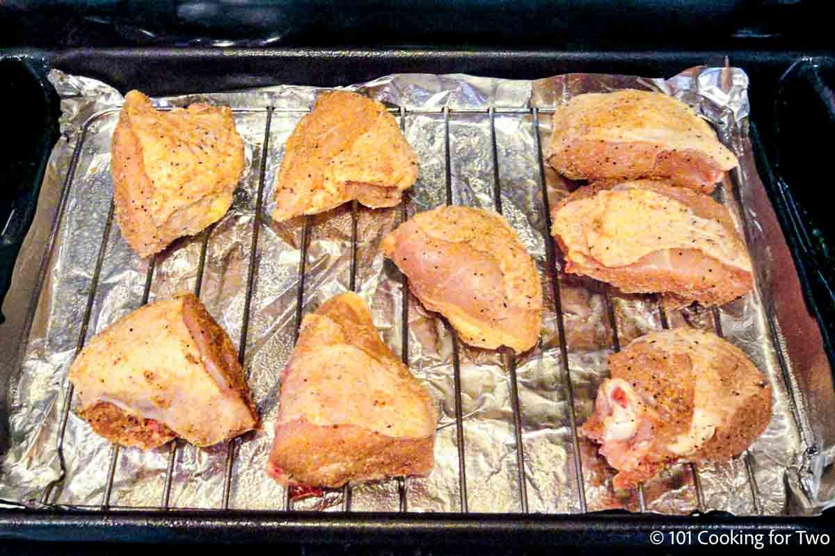 Seasoned ra.w chicken pieces on a baking tray