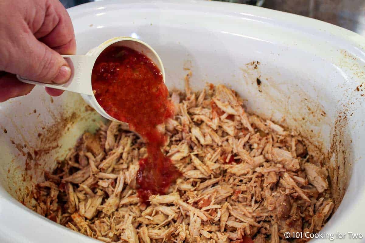 Adding BBQ sauce to pulled pork loin.