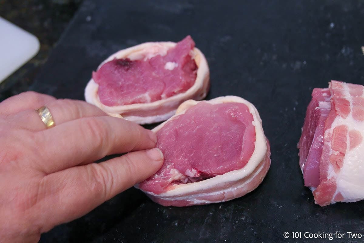 Flattening the meat into the bacon wrapper.