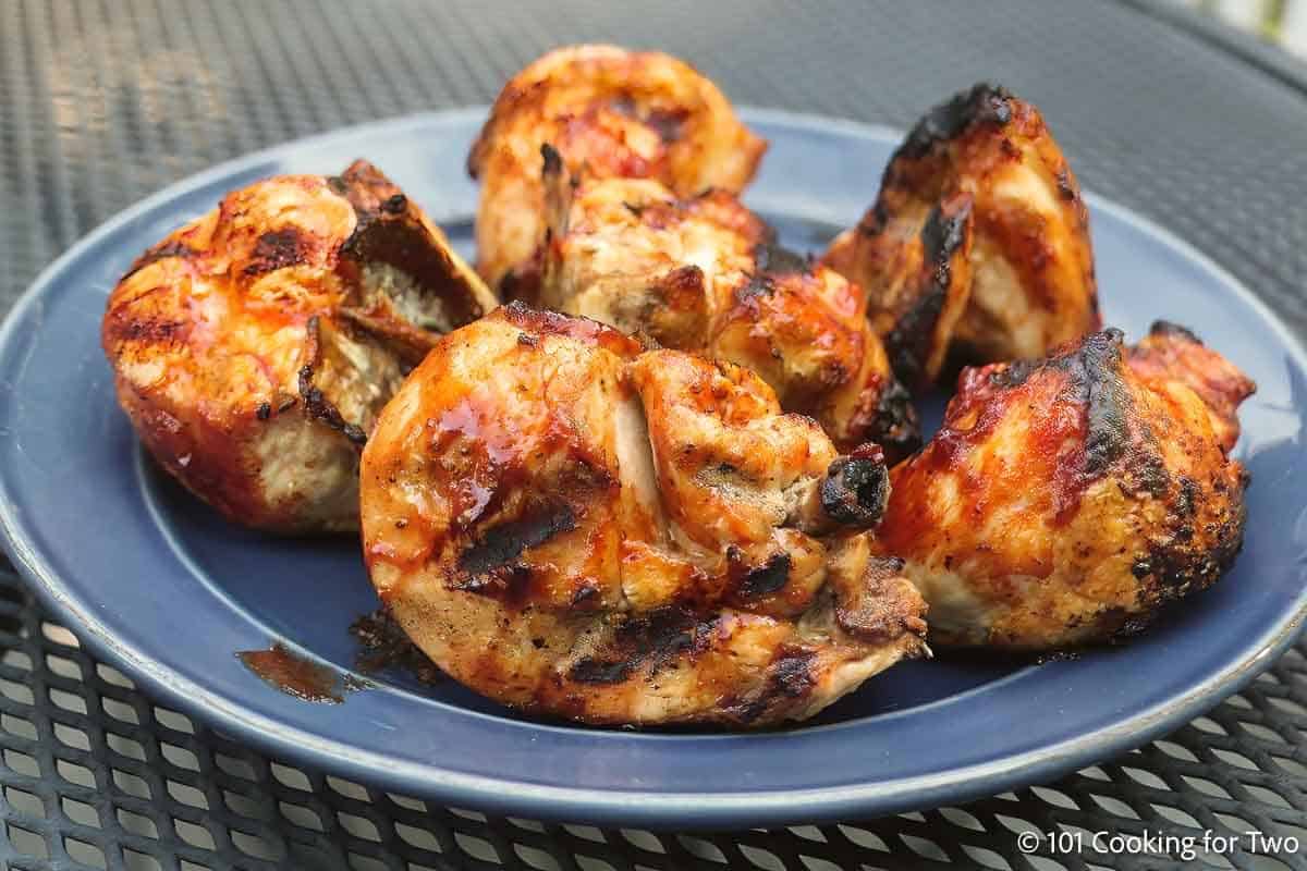 Bbq bone-in chicken breast on a blue plate.