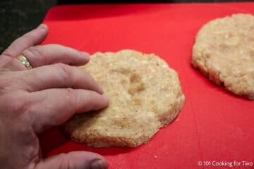 Dimpling the center of a chicken patty.