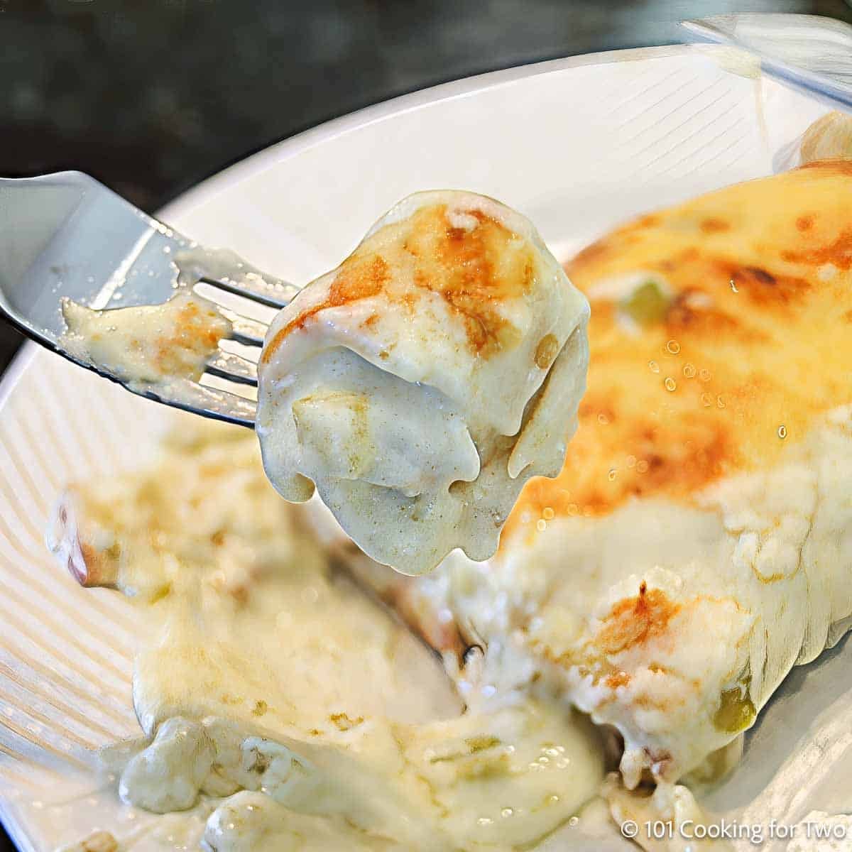 Easy Sour Cream Chicken Enchiladas Bite of sour cream chicken enchilada on a fork.