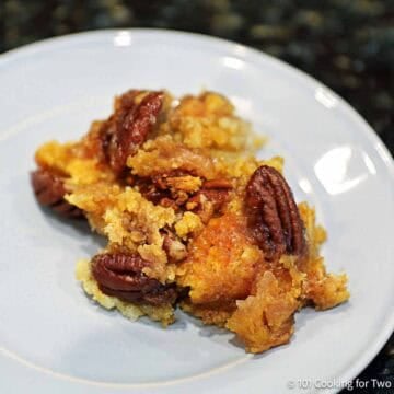 Small crock pot apple cobbler with golden cake mix topping on a plate