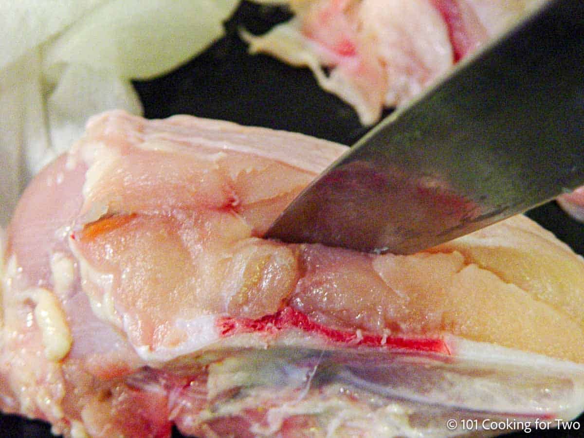 Cutting a pocket into a split chicken breast.